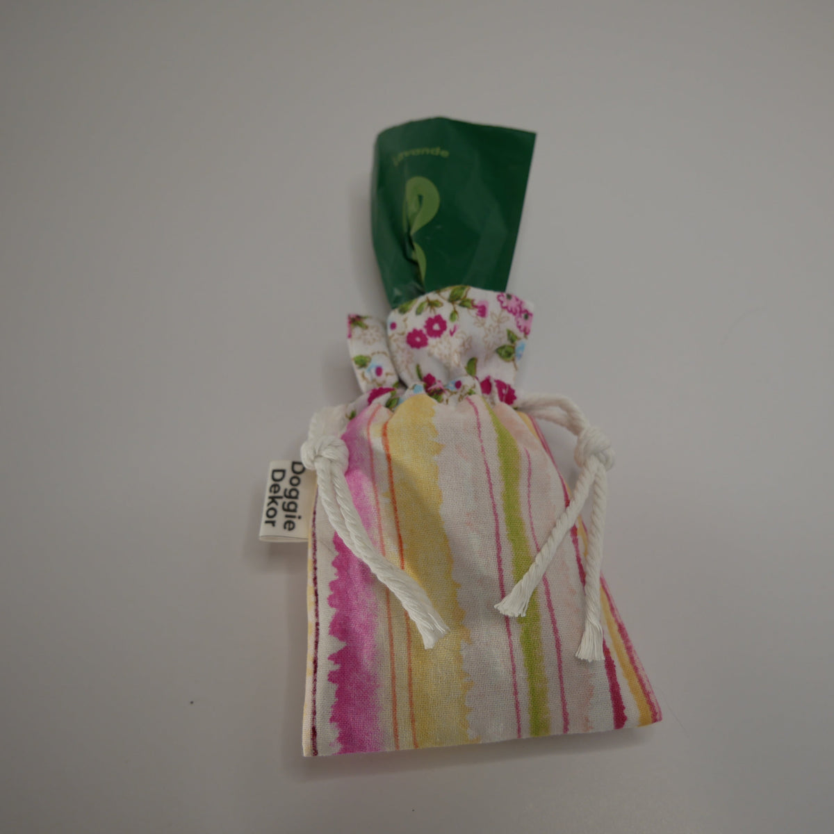 Dog poo bag roll holder in pink toned striped bottom and floral white collar - with a poo bag at the top - Doggie Dekor