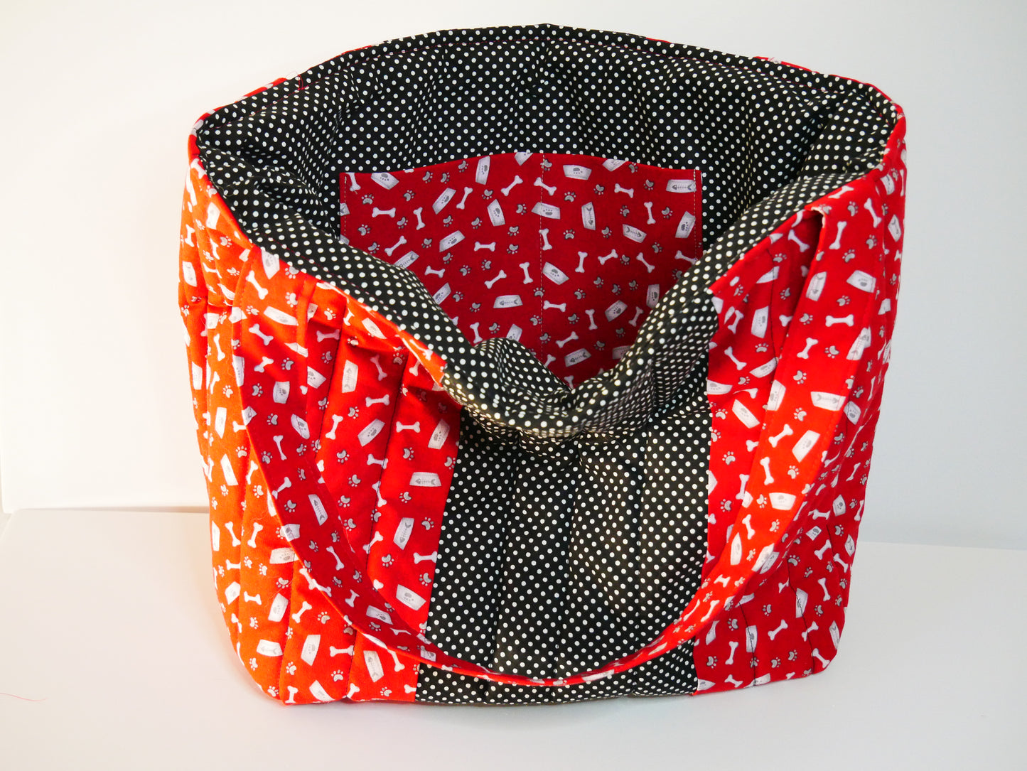 A red and white dog themed tote with black polka dots lining and matching front panel
