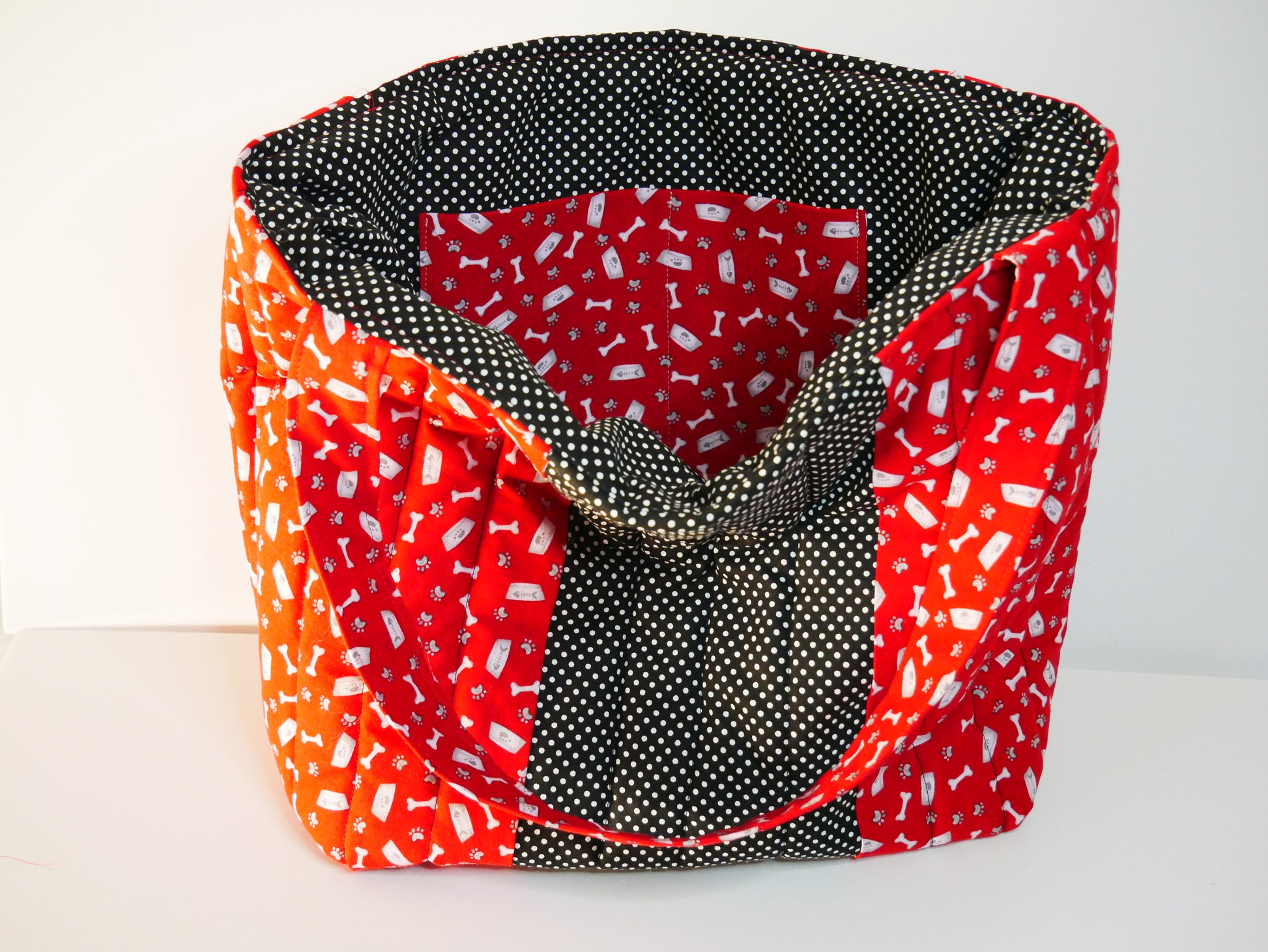 A red and white dog themed tote with black polka dots lining and matching front panel