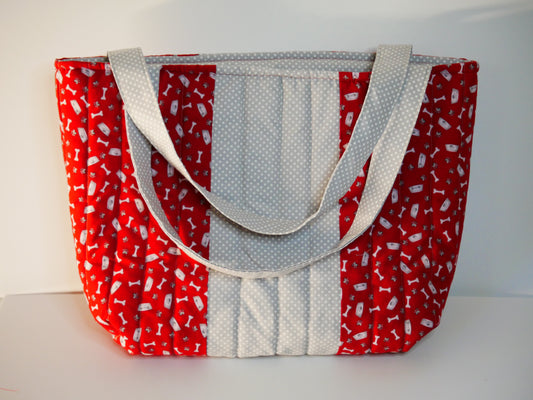 A handmade red and white dog themed fabric tote bag and coordinating light gray polka-dot handles, front panel and lining.