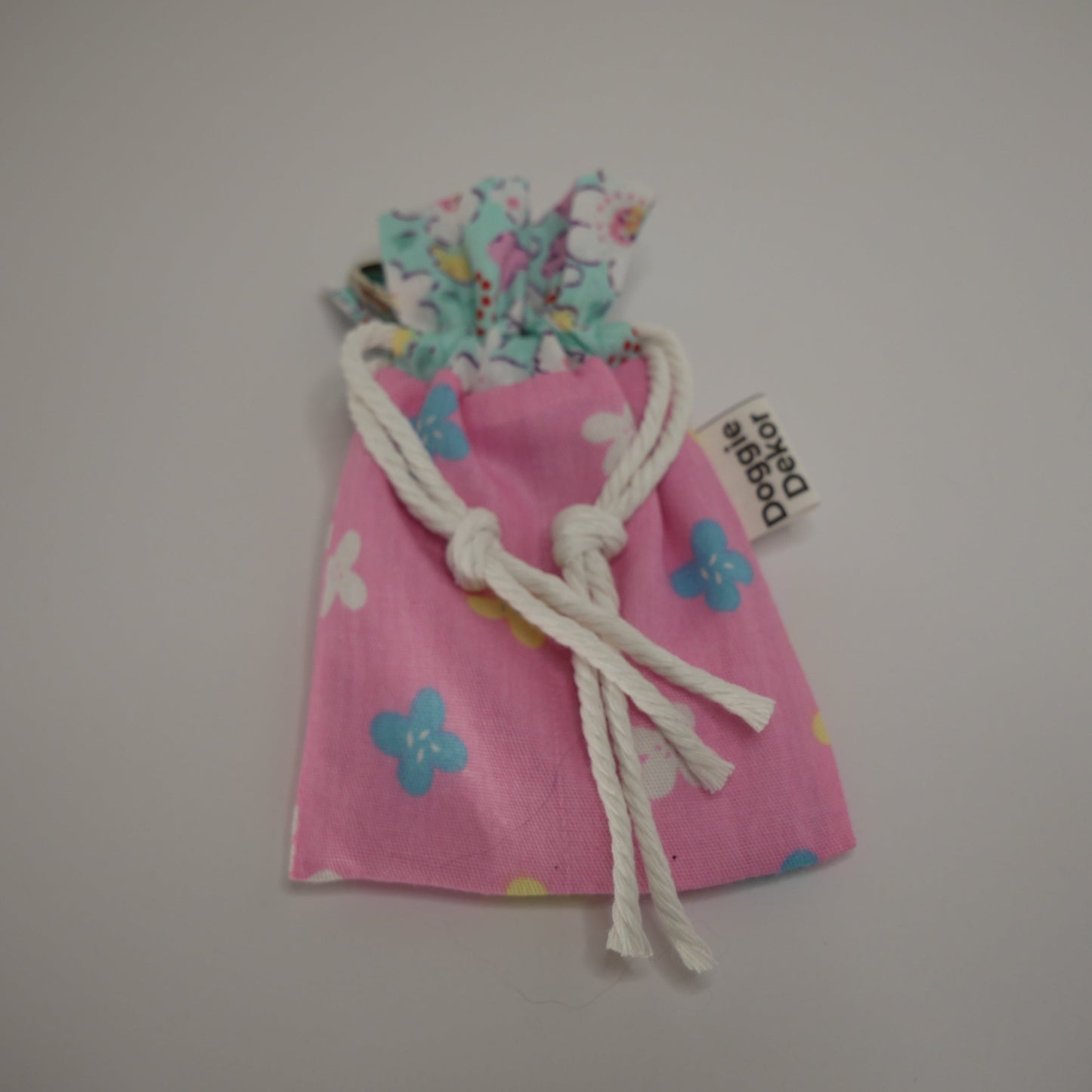 Dog poo bag roll holder in light pink with a blue floral collar - Doggie Dekor