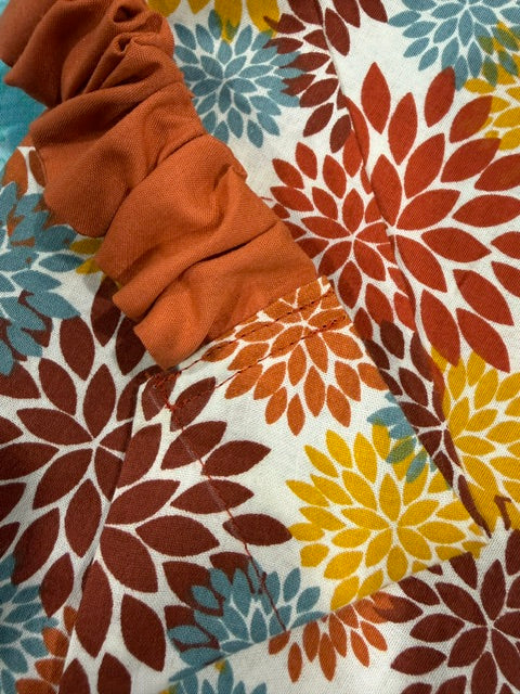 close up of a Scrunchie Dog Bandana in a rust, amber, burgundy and blue abstract floral print fabric - Doggie Dekor