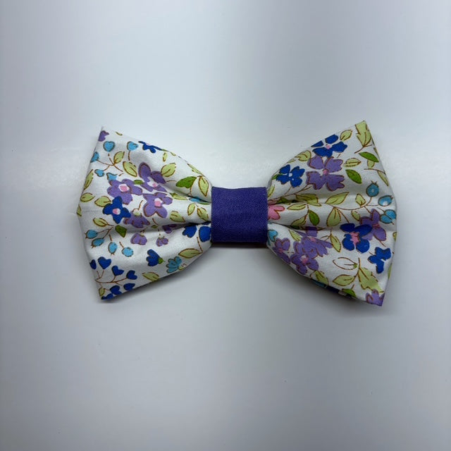 Floral patterned bow tie with a purple center on a light gray background