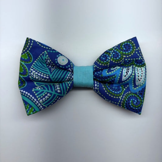 Blue and green patterned bow tie on a light gray background