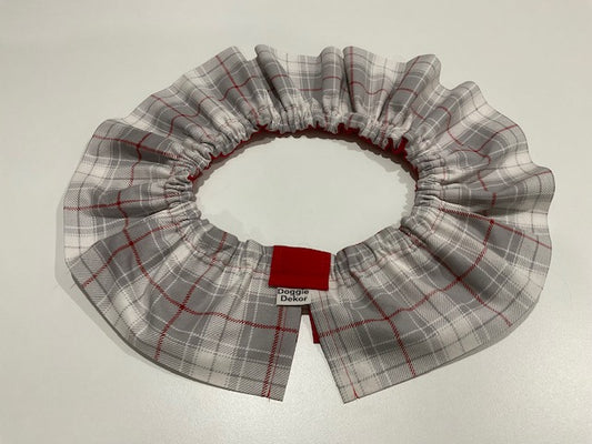 A neck ruffle by doggie dekor in a light grey plaid with red accents